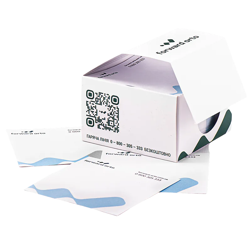 Відкрита коробка для кубарика з QR-кодом і зеленими елементами оформлення поруч з аркушами для нотаток