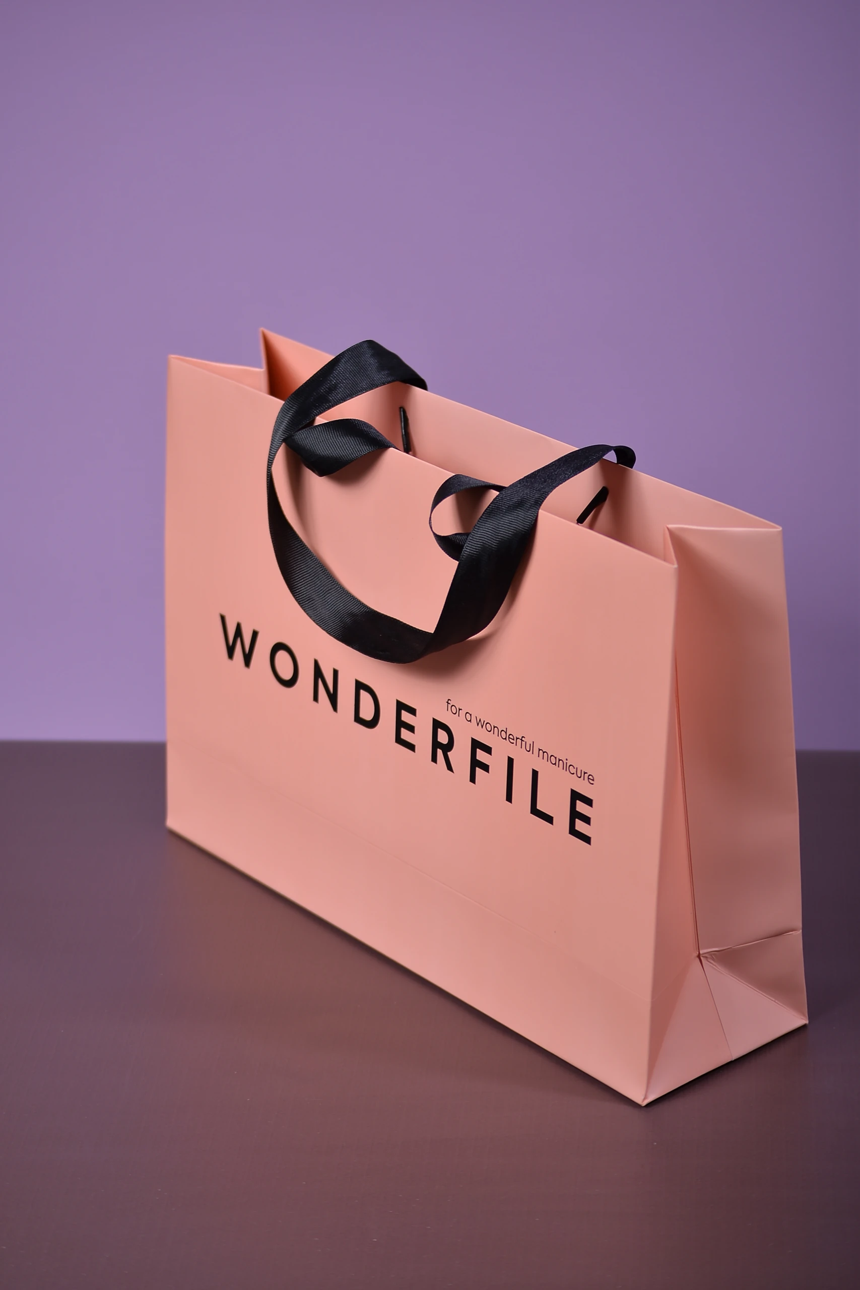 Пакет WONDERFILE у ракурсі збоку: чорні репсові ручки, верхній край і згини боковини.