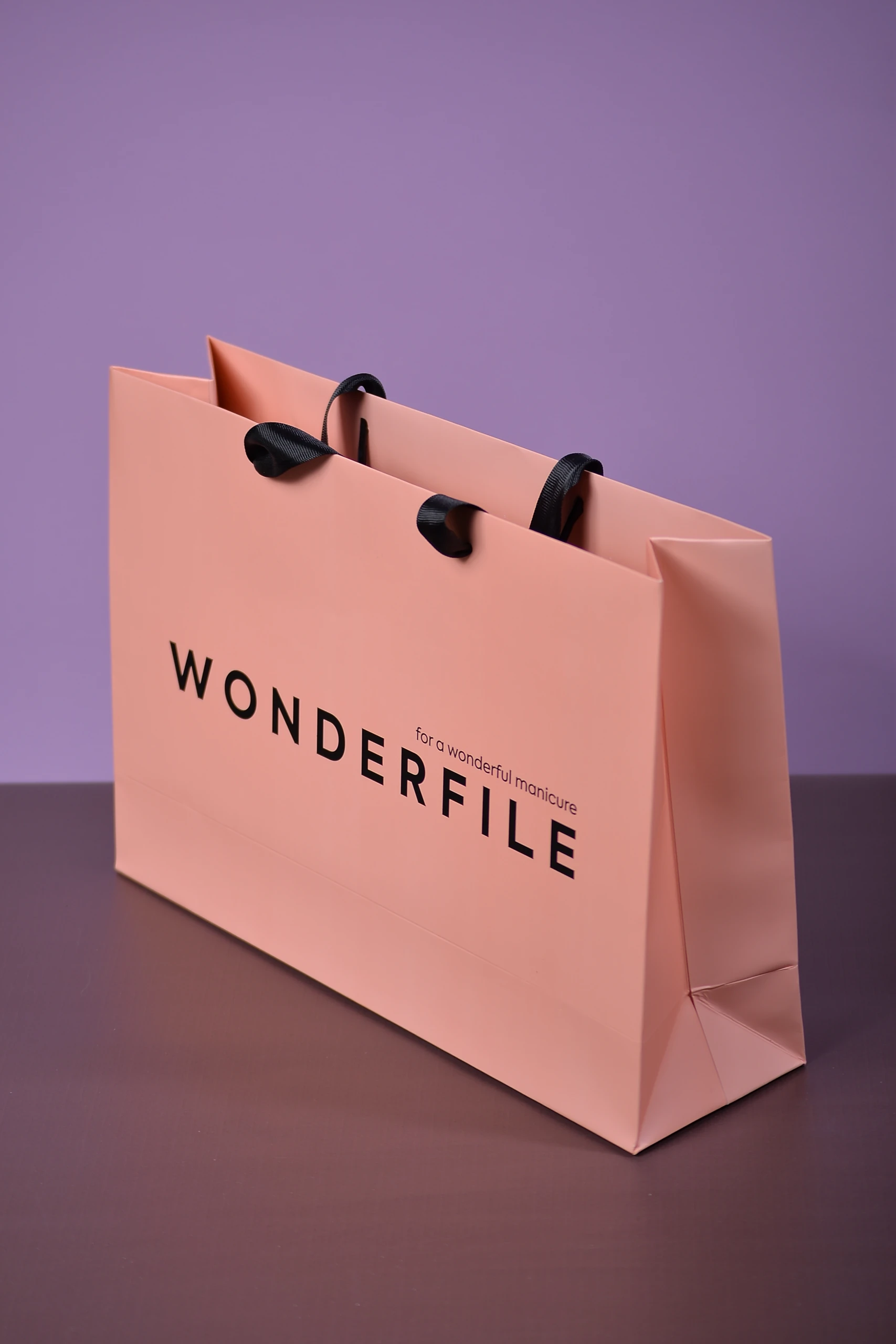 Верхній край пакета WONDERFILE із вклеєними репсовими ручками-стрічками.