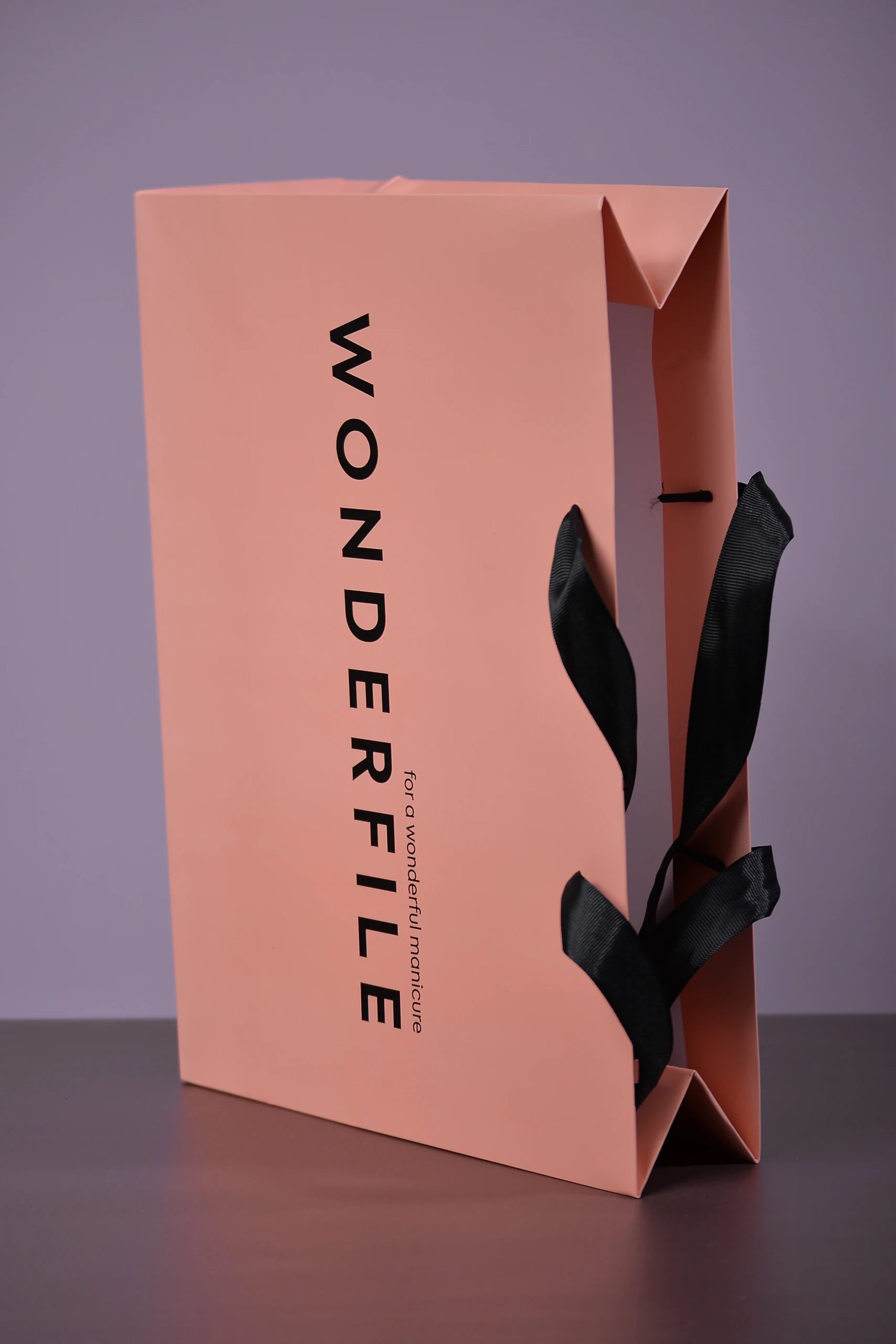 Вигляд зверху на пакет WONDERFILE: чорні репсові ручки-стрічки та їхнє кріплення зсередини.