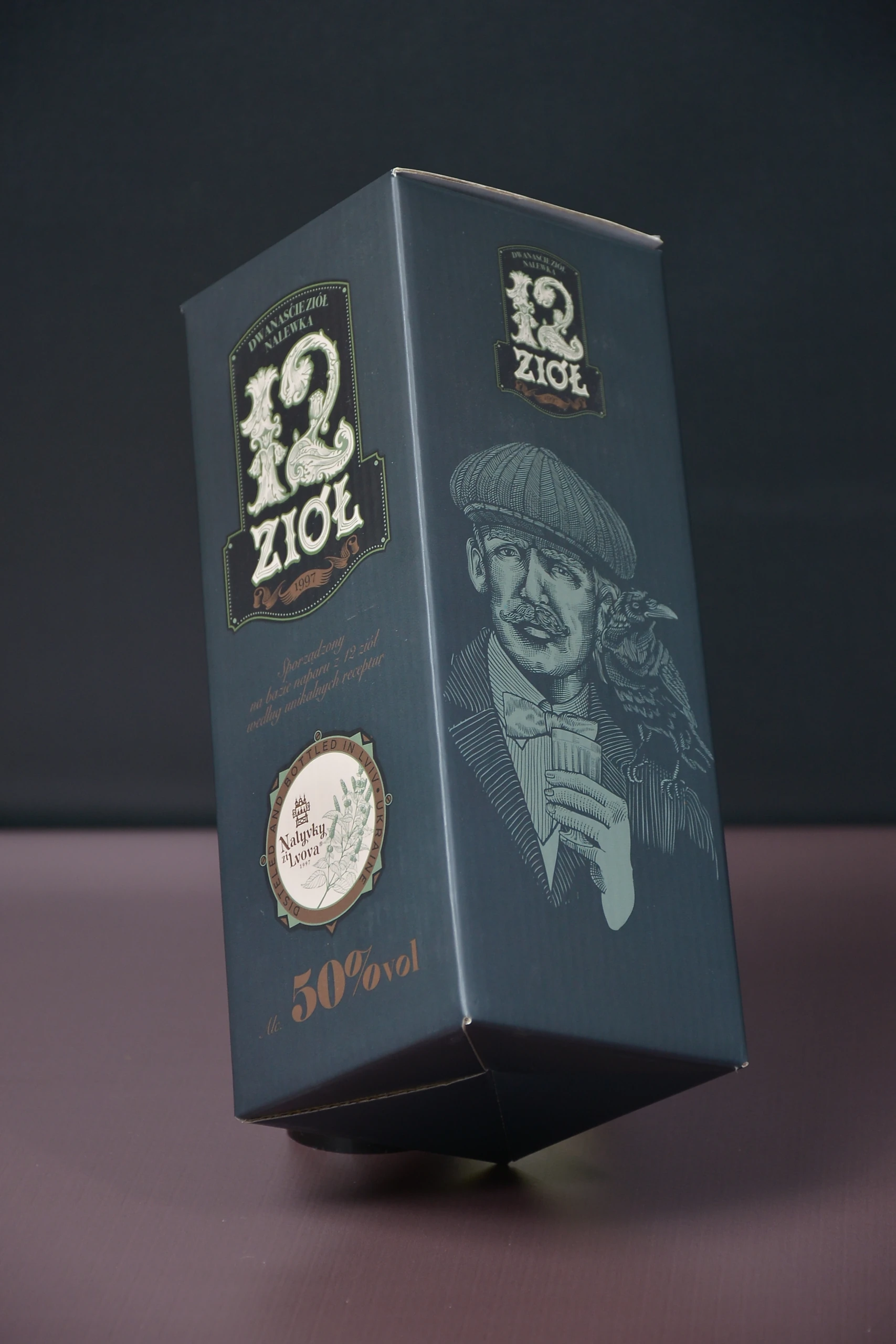 Вертикальна коробка «12 Ziół» із темним тлом, орнаментальною назвою та портретною ілюстрацією.